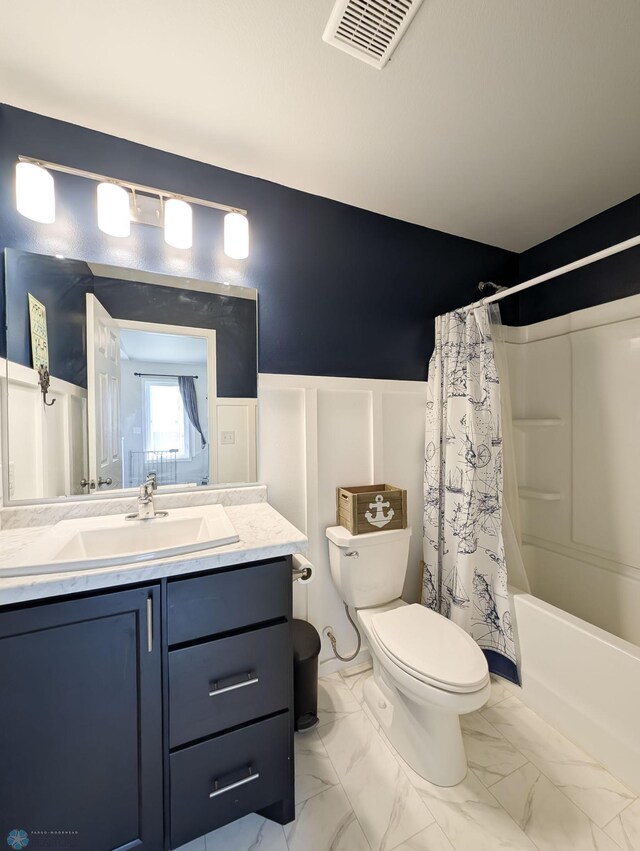 1506 67th Ave S, Fargo, ND 58104 - full bath with toilet, vanity, wainscoting, a decorative wall, and marble look tile flooring
