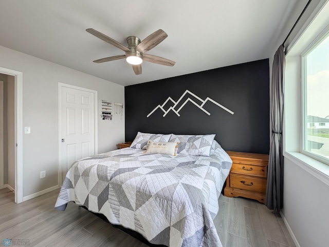 1506 67th Ave S, Fargo, ND 58104 - bedroom with light wood finished floors, baseboards, ceiling fan, and an accent wall