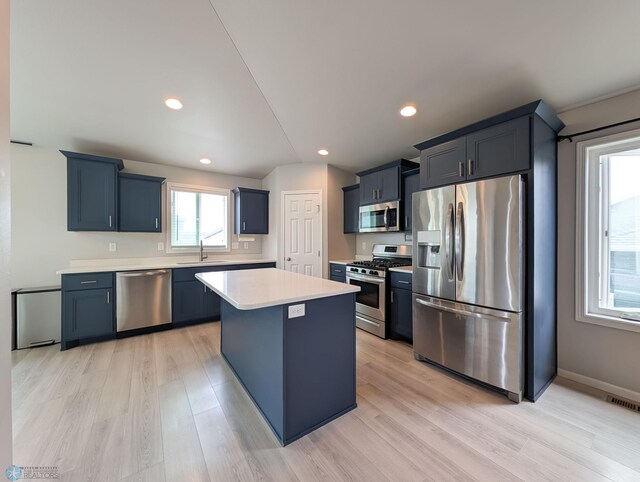 1506 67th Ave S, Fargo, ND 58104 - kitchen featuring appliances with stainless steel finishes, light countertops, a center island, light wood-style floors, and a sink