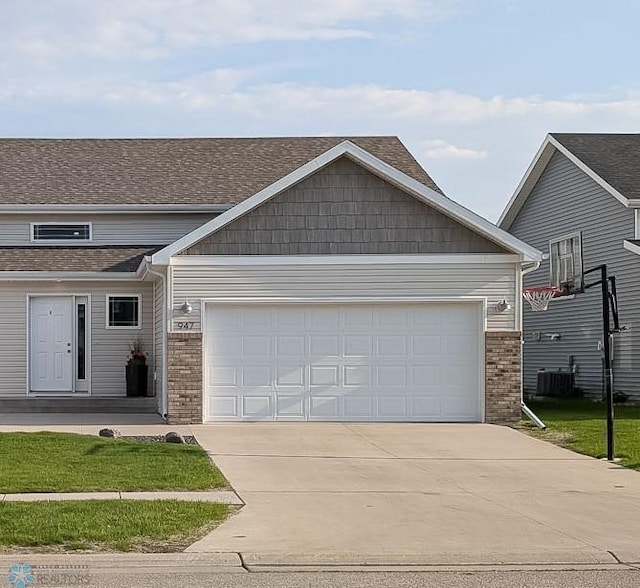 947 Eaglewood Ave W, West Fargo, ND 58078 - view of front of property with concrete driveway, brick siding, an attached garage, and central air condition unit