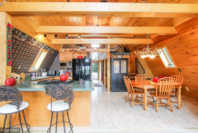 66893 185th Pl, Jacobson, MN 55752 - kitchen featuring freestanding refrigerator, wood walls, stainless steel microwave, a peninsula, and a sink