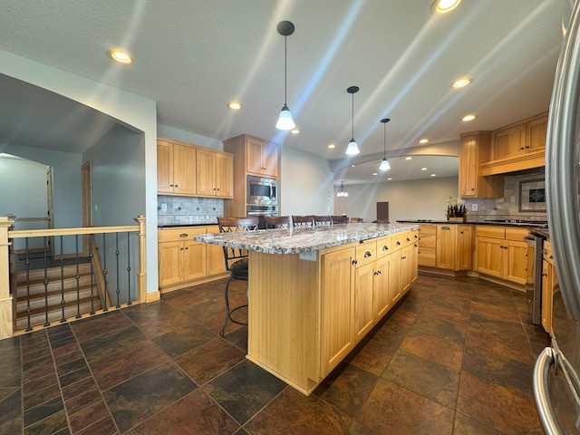 25797 Silver Beach Rd, Minnewaska Twp, MN 56334 - kitchen with appliances with stainless steel finishes, tasteful backsplash, a kitchen bar, a center island, and recessed lighting
