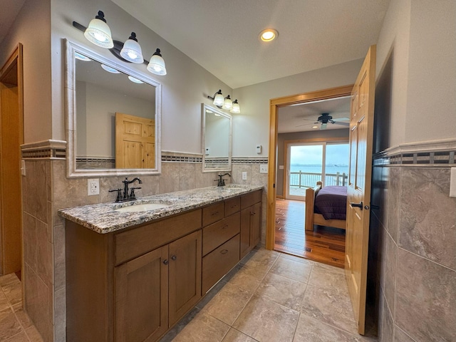 25797 Silver Beach Rd, Minnewaska Twp, MN 56334 - full bath featuring tile walls, double vanity, wainscoting, ensuite bathroom, and a ceiling fan