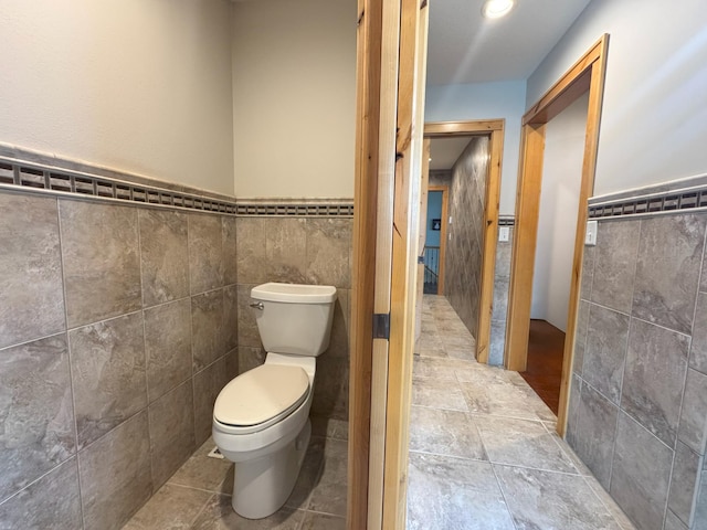 25797 Silver Beach Rd, Minnewaska Twp, MN 56334 - bathroom featuring tile walls, toilet, and a wainscoted wall
