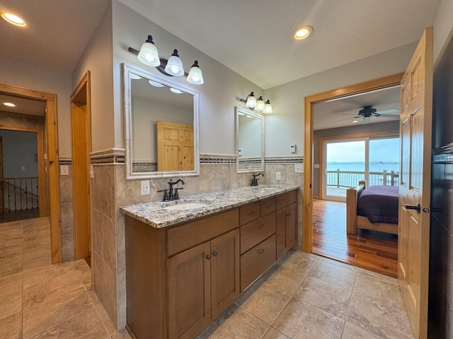 25797 Silver Beach Rd, Minnewaska Twp, MN 56334 - full bathroom featuring tile walls, connected bathroom, double vanity, recessed lighting, and wainscoting