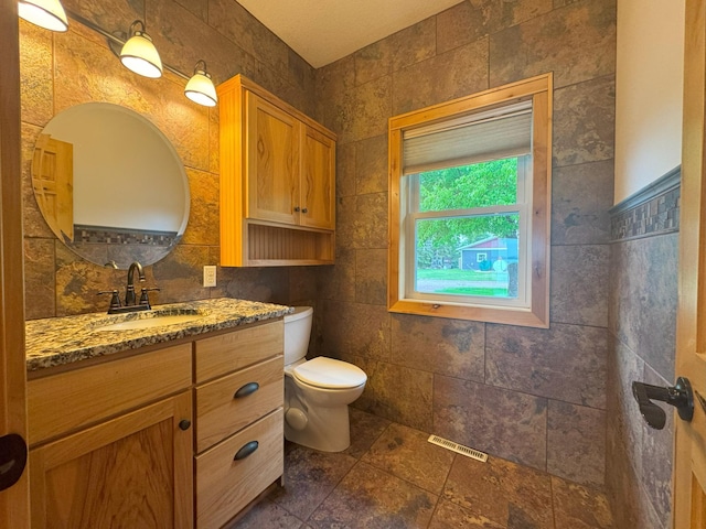 25797 Silver Beach Rd, Minnewaska Twp, MN 56334 - bathroom with toilet, vanity, and tile walls