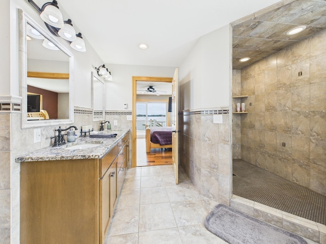 25797 Silver Beach Rd, Minnewaska Twp, MN 56334 - ensuite bathroom featuring tile walls, double vanity, walk in shower, a ceiling fan, and wainscoting