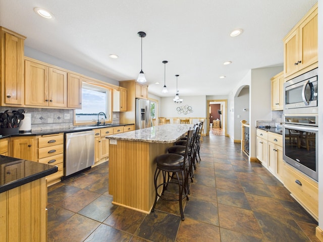 25797 Silver Beach Rd, Minnewaska Twp, MN 56334 - kitchen featuring stainless steel appliances, light brown cabinets, a center island, backsplash, and recessed lighting
