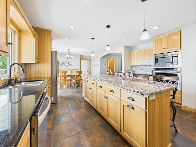 25797 Silver Beach Rd, Minnewaska Twp, MN 56334 - kitchen featuring appliances with stainless steel finishes, light brown cabinets, decorative backsplash, a center island, and arched walkways