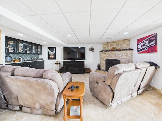 25797 Silver Beach Rd, Minnewaska Twp, MN 56334 - living area featuring a stone fireplace, a paneled ceiling, light tile patterned floors, bar with sink, and recessed lighting
