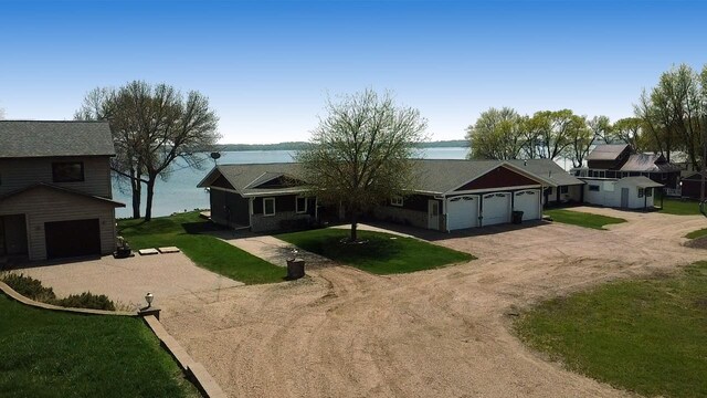 25797 Silver Beach Rd, Minnewaska Twp, MN 56334 - view of front facade featuring driveway, a garage, a water view, and a front yard