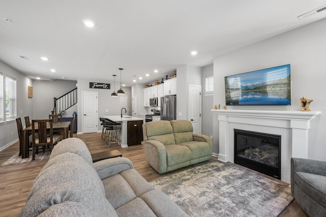 3011 Rum River Way, Anoka, MN 55303 - living room featuring wood finished floors, plenty of natural light, stairs, recessed lighting, and baseboards