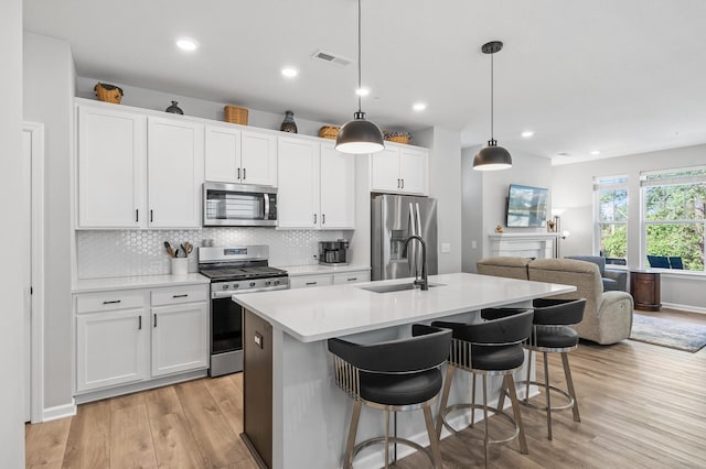 3011 Rum River Way, Anoka, MN 55303 - kitchen with appliances with stainless steel finishes, a sink, light wood finished floors, light countertops, and backsplash