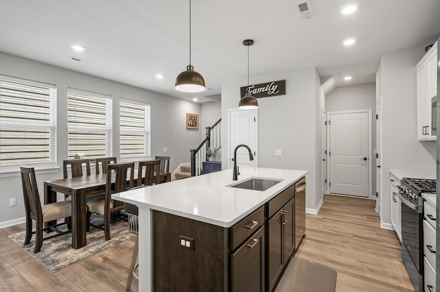 3011 Rum River Way, Anoka, MN 55303 - kitchen featuring a sink, gas range oven, light wood-type flooring, dark brown cabinets, and recessed lighting