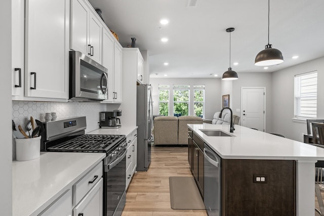 3011 Rum River Way, Anoka, MN 55303 - kitchen featuring stainless steel appliances, a sink, open floor plan, light wood-type flooring, and recessed lighting