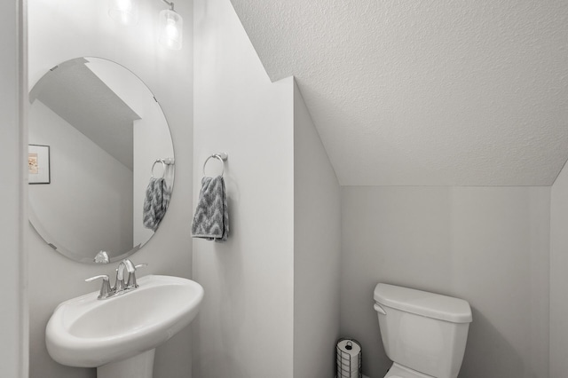3011 Rum River Way, Anoka, MN 55303 - half bathroom featuring lofted ceiling, a sink, toilet, and a textured ceiling
