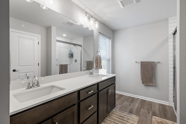 3011 Rum River Way, Anoka, MN 55303 - bathroom featuring double vanity, wood finished floors, a stall shower, and baseboards