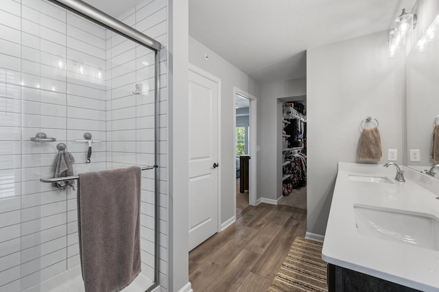 3011 Rum River Way, Anoka, MN 55303 - full bath featuring a shower stall, wood finished floors, double vanity, a walk in closet, and baseboards