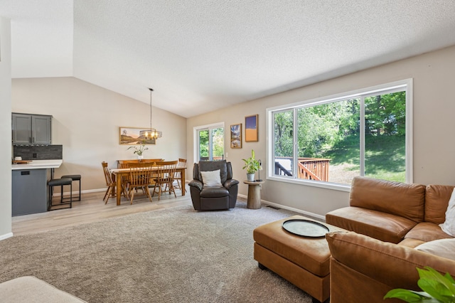 805 Natalie Dr, Buffalo, MN 55313 - living area featuring lofted ceiling, baseboards, a textured ceiling, and a chandelier
