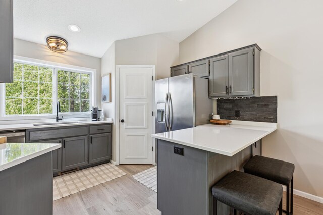 805 Natalie Dr, Buffalo, MN 55313 - kitchen with appliances with stainless steel finishes, gray cabinets, decorative backsplash, a peninsula, and lofted ceiling