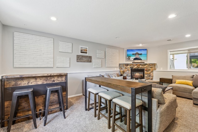 805 Natalie Dr, Buffalo, MN 55313 - living area with light carpet, a stone fireplace, recessed lighting, a textured ceiling, and baseboards