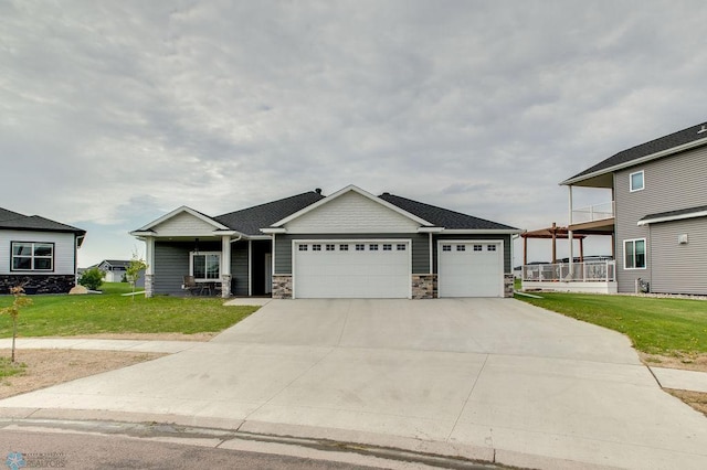 1908 65th Ave S, Fargo, ND 58104 - craftsman inspired home featuring an attached garage, a front lawn, driveway, stone siding, and a porch