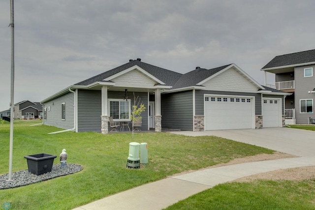 1908 65th Ave S, Fargo, ND 58104 - craftsman-style house with stone siding, an attached garage, a front yard, and driveway
