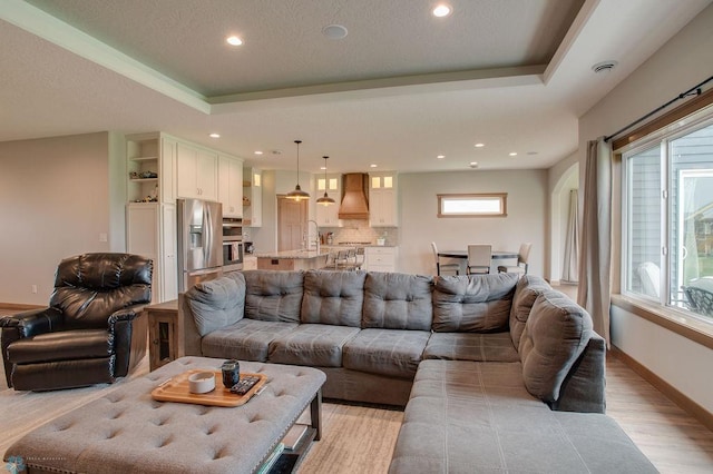 1908 65th Ave S, Fargo, ND 58104 - living area with a tray ceiling, recessed lighting, light wood-style flooring, and baseboards