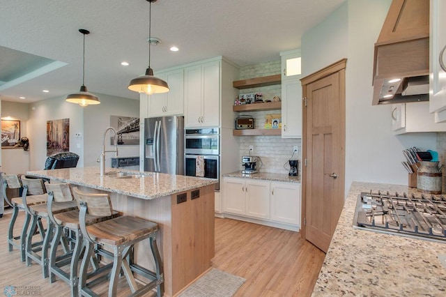 1908 65th Ave S, Fargo, ND 58104 - kitchen featuring a sink, stainless steel appliances, light wood-style flooring, backsplash, and white cabinets