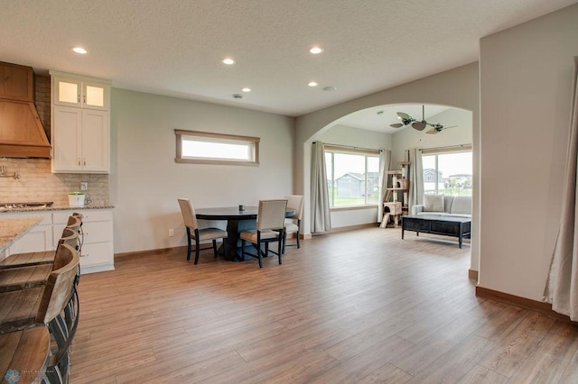 1908 65th Ave S, Fargo, ND 58104 - dining area featuring recessed lighting, arched walkways, light wood-style floors, plenty of natural light, and a textured ceiling