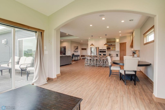 1908 65th Ave S, Fargo, ND 58104 - living room with arched walkways, light wood-style flooring, recessed lighting, and baseboards
