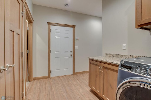 1908 65th Ave S, Fargo, ND 58104 - kitchen featuring washer / dryer, light wood-type flooring, light stone counters, and baseboards