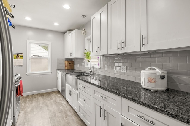 469 Little Canada Rd E, Little Canada, MN 55117 - kitchen with stainless steel appliances, baseboards, white cabinets, a sink, and backsplash