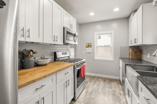 469 Little Canada Rd E, Little Canada, MN 55117 - kitchen with appliances with stainless steel finishes, wood counters, baseboards, light wood-type flooring, and a sink