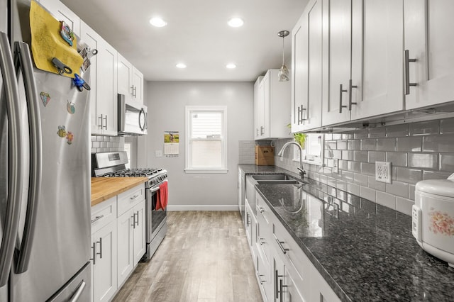 469 Little Canada Rd E, Little Canada, MN 55117 - kitchen featuring appliances with stainless steel finishes, baseboards, backsplash, a sink, and light wood-type flooring