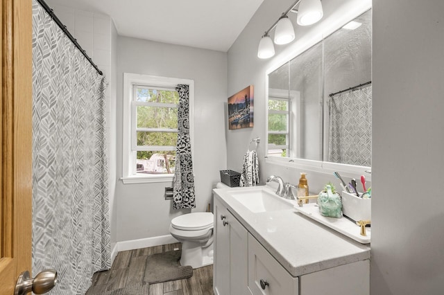 469 Little Canada Rd E, Little Canada, MN 55117 - bathroom featuring vanity, toilet, wood finished floors, and healthy amount of natural light