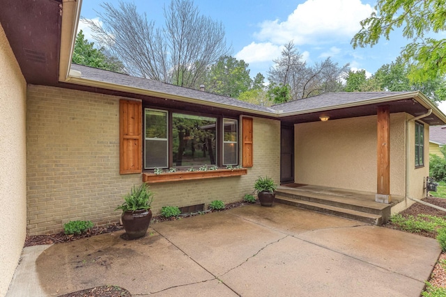 5725 Golden Valley Rd, Golden Valley, MN 55422 - doorway to property with brick siding, a patio, and roof with shingles