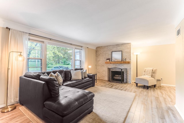 5725 Golden Valley Rd, Golden Valley, MN 55422 - living area with light wood-style floors, a brick fireplace, and baseboards