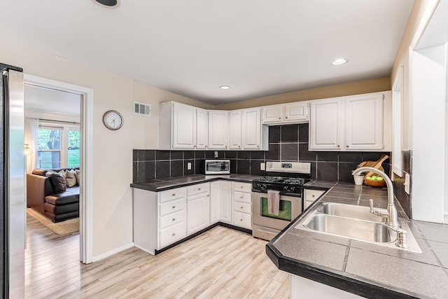 5725 Golden Valley Rd, Golden Valley, MN 55422 - kitchen featuring appliances with stainless steel finishes, a sink, white cabinetry, dark countertops, and recessed lighting