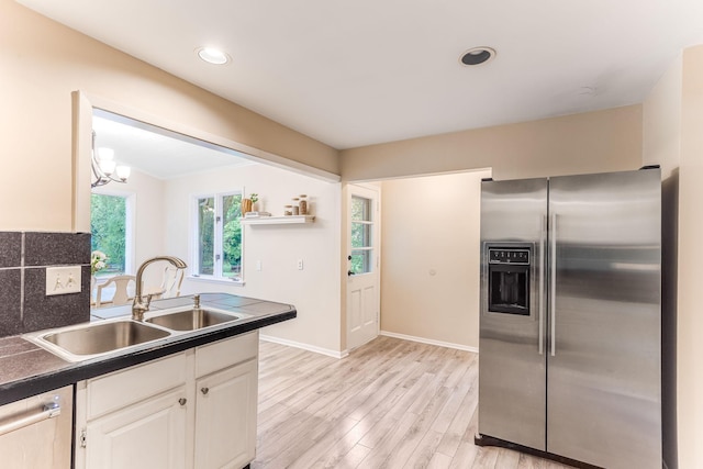 5725 Golden Valley Rd, Golden Valley, MN 55422 - kitchen with stainless steel fridge, a sink, light wood finished floors, baseboards, and white cabinets