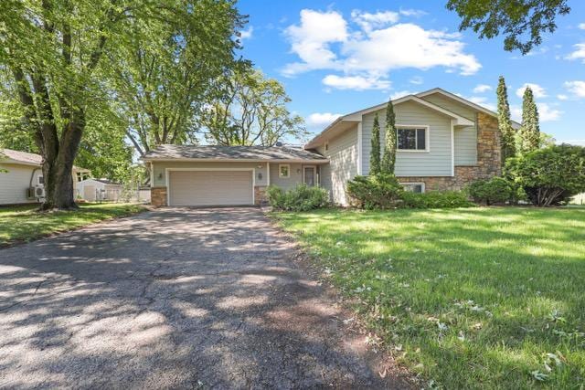 720 Tanglewood Dr, Shoreview, MN 55126 - split level home with asphalt driveway, an attached garage, a front lawn, and stone siding