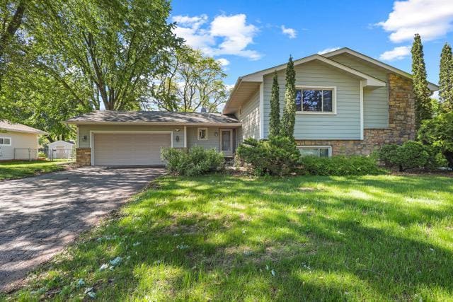 720 Tanglewood Dr, Shoreview, MN 55126 - split level home featuring asphalt driveway, an attached garage, a front yard, and stone siding