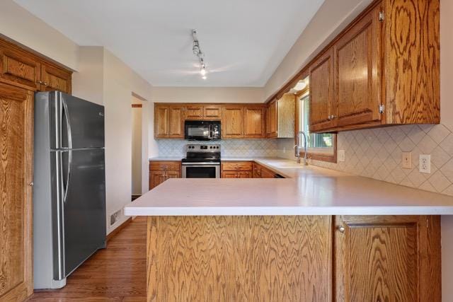 720 Tanglewood Dr, Shoreview, MN 55126 - kitchen featuring appliances with stainless steel finishes, a sink, light countertops, wood finished floors, and a peninsula