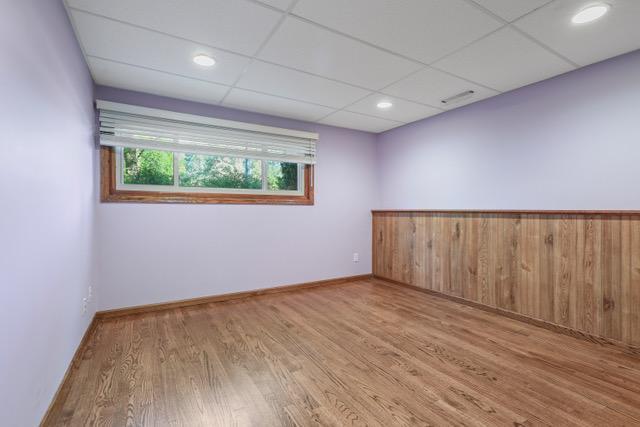 720 Tanglewood Dr, Shoreview, MN 55126 - spare room featuring wood finished floors, a paneled ceiling, and baseboards