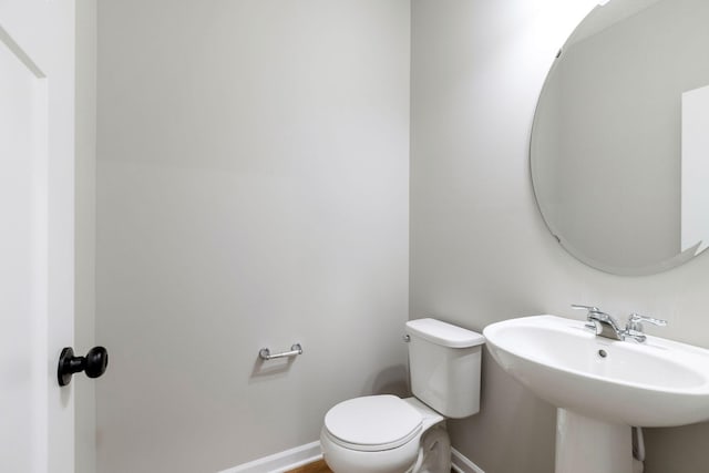 23225 Creekview Ct, Rogers, MN 55374 - bathroom with toilet, baseboards, and a sink