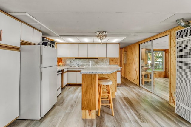 24505 Twilight Ln, Lida Twp, MN 56572 - kitchen with white appliances, a heating unit, light countertops, a kitchen bar, and white cabinets