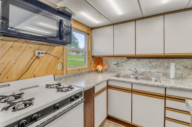 24505 Twilight Ln, Lida Twp, MN 56572 - kitchen with black microwave, white gas range, light countertops, and white cabinetry