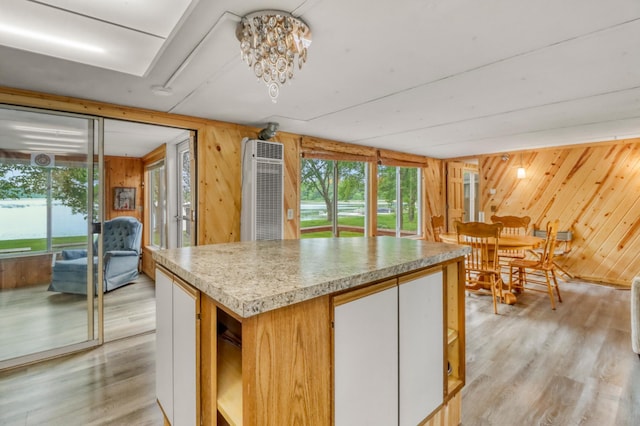 24505 Twilight Ln, Lida Twp, MN 56572 - kitchen featuring wooden walls, light wood-style flooring, a heating unit, light countertops, and a center island