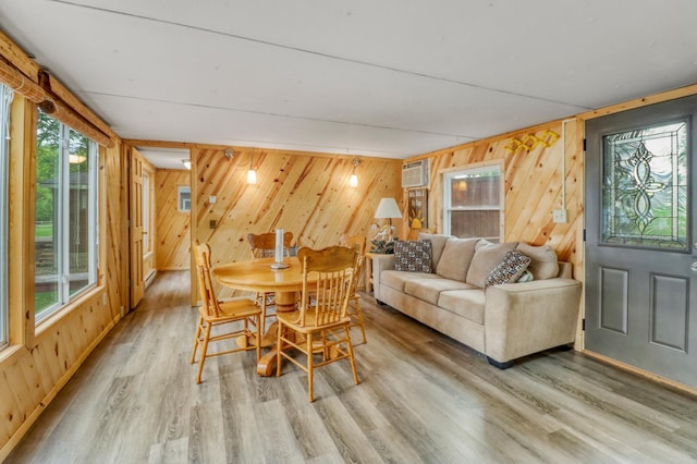 24505 Twilight Ln, Lida Twp, MN 56572 - dining room featuring wood walls, light wood-style flooring, and a wall unit AC