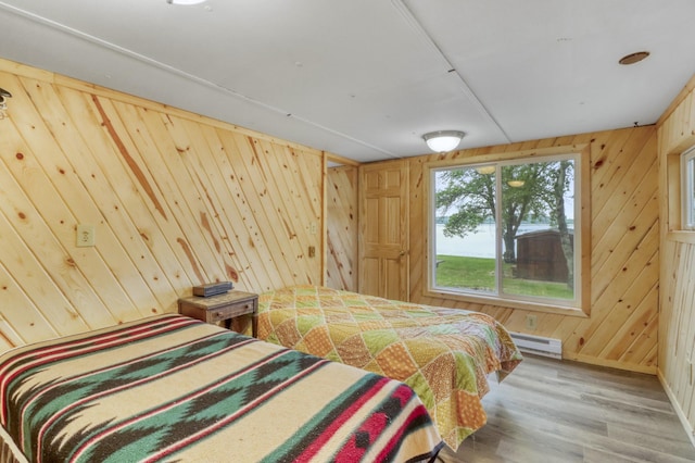 24505 Twilight Ln, Lida Twp, MN 56572 - bedroom with baseboard heating, wood walls, wood finished floors, and a water view